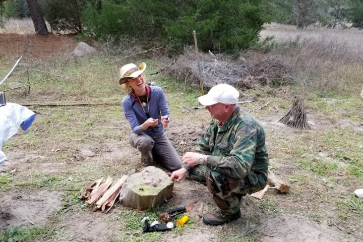 texas survival school_ Woman student learning fire craft with staff